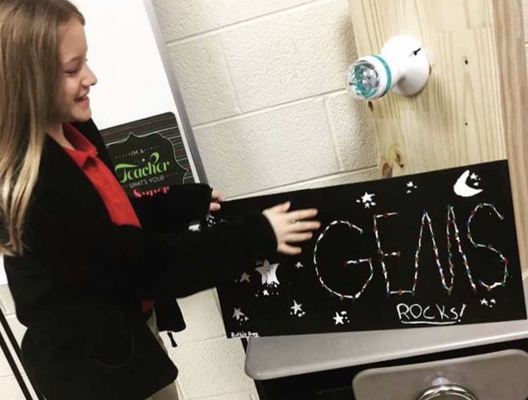 Student with sign that says GEMS Rocks! Student with sign that says GEMS Rocks!